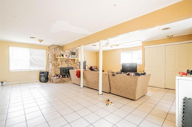 tiled living room featuring ceiling fan and a fireplace