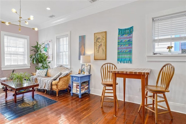 sitting room with plenty of natural light, baseboards, an inviting chandelier, and hardwood / wood-style floors