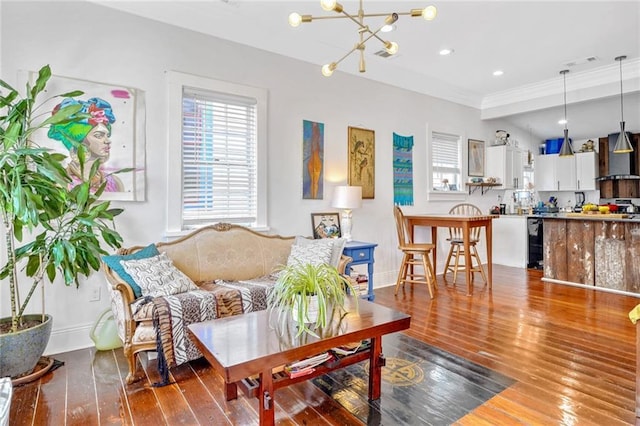 living room featuring baseboards, visible vents, an inviting chandelier, recessed lighting, and wood-type flooring