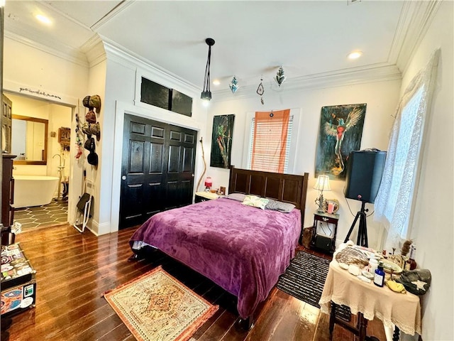 bedroom with a closet, crown molding, baseboards, and wood-type flooring