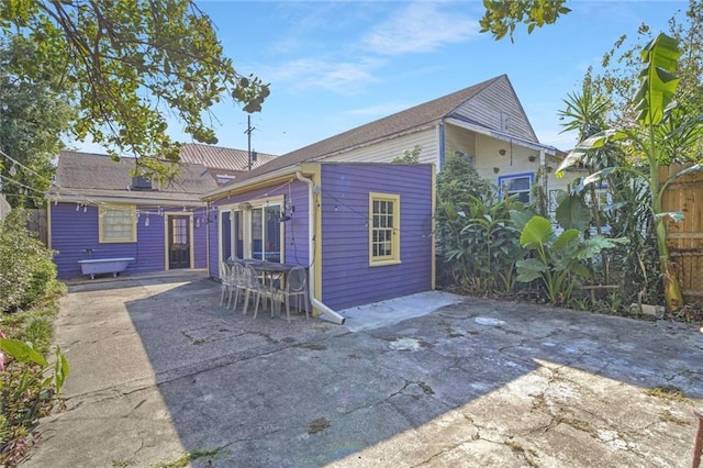 rear view of property featuring a patio and fence