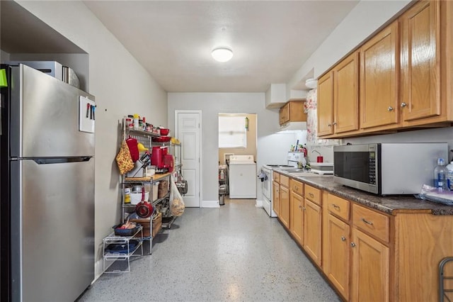 kitchen with stainless steel appliances, washer / clothes dryer, and range hood