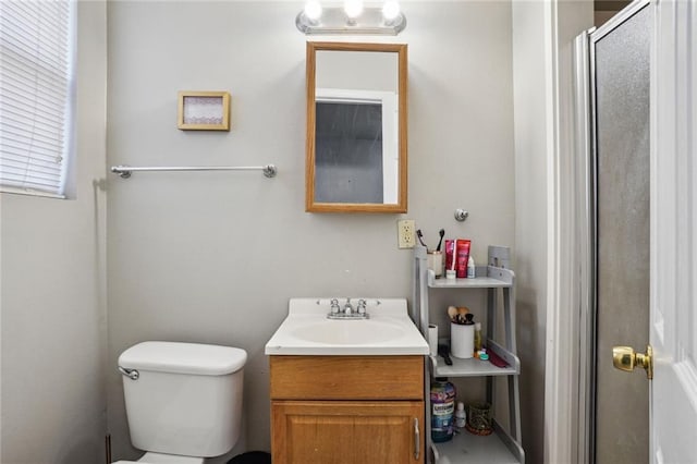 bathroom with an enclosed shower, vanity, and toilet