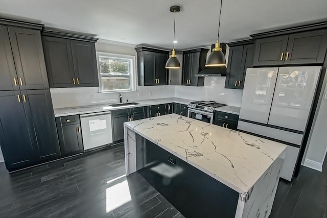 kitchen with wall chimney range hood, appliances with stainless steel finishes, sink, a center island, and decorative light fixtures