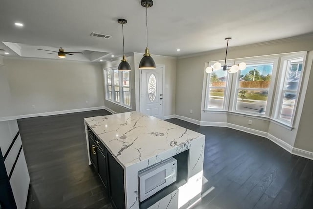 kitchen with crown molding, pendant lighting, ceiling fan with notable chandelier, and dark hardwood / wood-style flooring