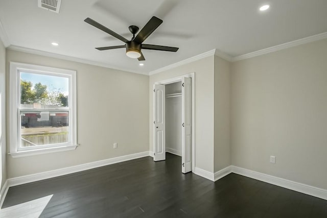 unfurnished bedroom featuring dark hardwood / wood-style flooring, crown molding, a closet, and ceiling fan