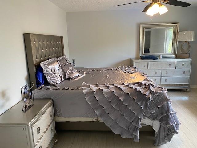 unfurnished bedroom featuring light hardwood / wood-style floors, a textured ceiling, and ceiling fan