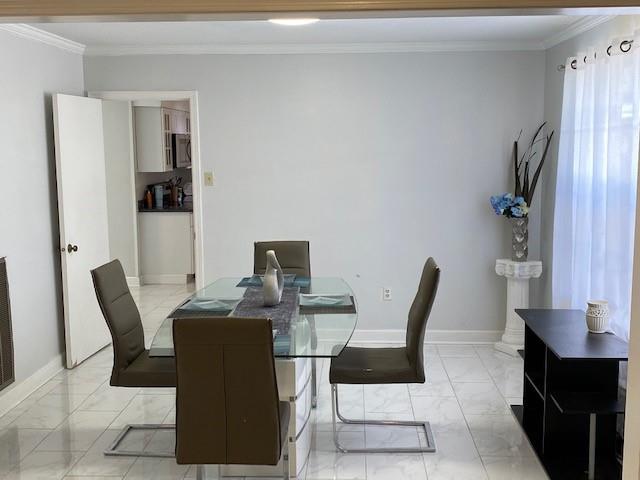 dining space featuring crown molding