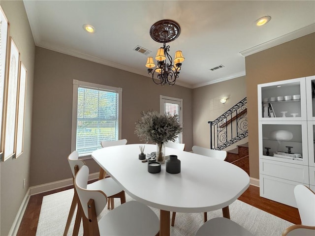 dining space featuring a chandelier, dark hardwood / wood-style floors, and ornamental molding