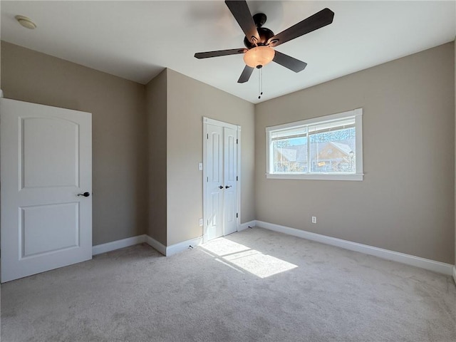 unfurnished bedroom with light carpet, a closet, and ceiling fan