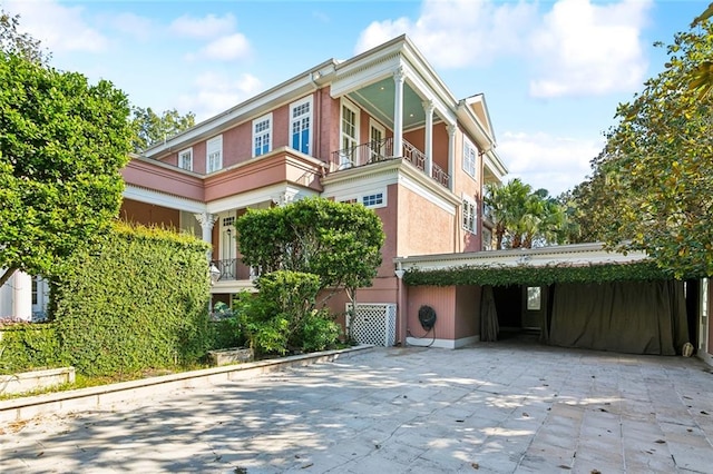 view of front facade with a balcony and a carport