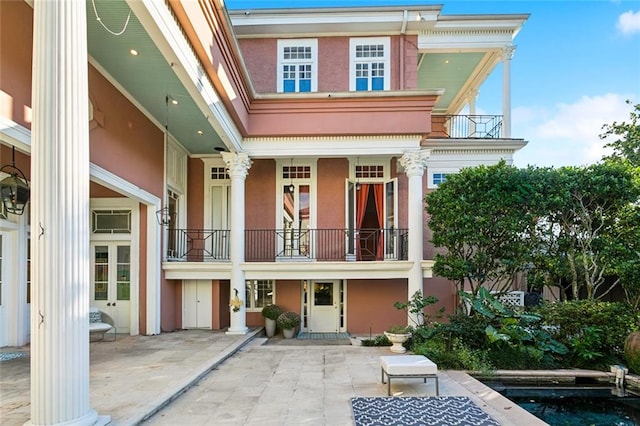 rear view of house featuring a patio area and a balcony