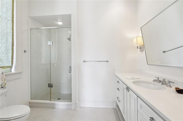 bathroom featuring toilet, vanity, tile patterned flooring, and a shower with door