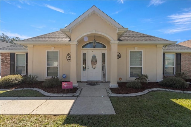 property entrance featuring a lawn