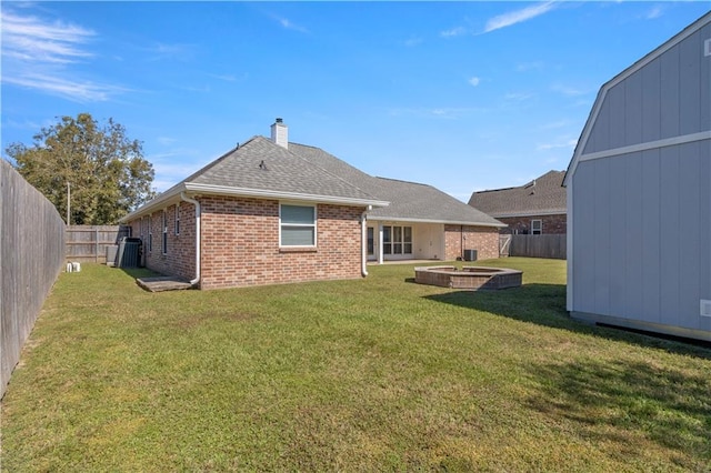 rear view of property featuring a shed, a patio, and a lawn