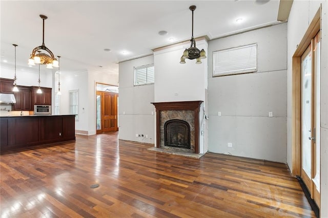 unfurnished living room featuring ornamental molding and dark hardwood / wood-style flooring