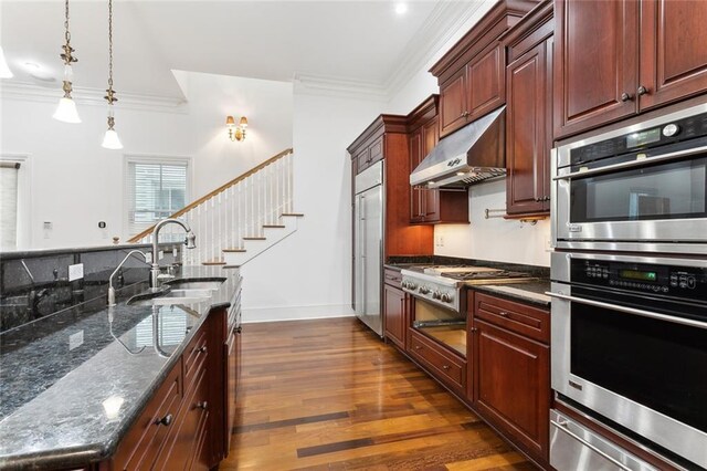 kitchen with dark wood-type flooring, ornamental molding, and pendant lighting