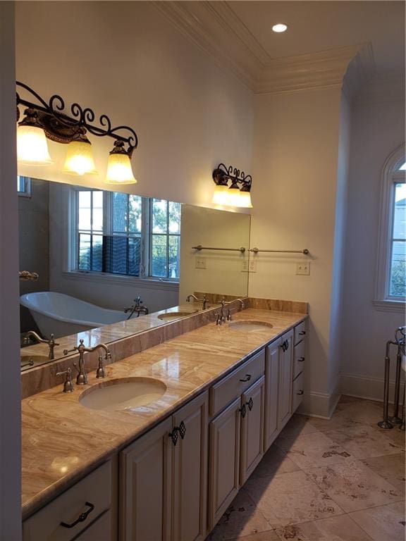 bathroom featuring vanity, crown molding, and a bathtub