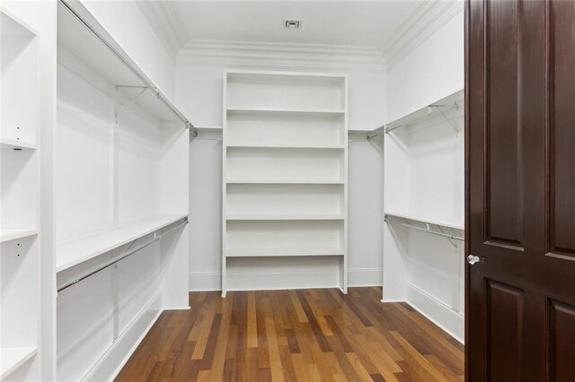 unfurnished living room featuring a high end fireplace, crown molding, and dark hardwood / wood-style floors