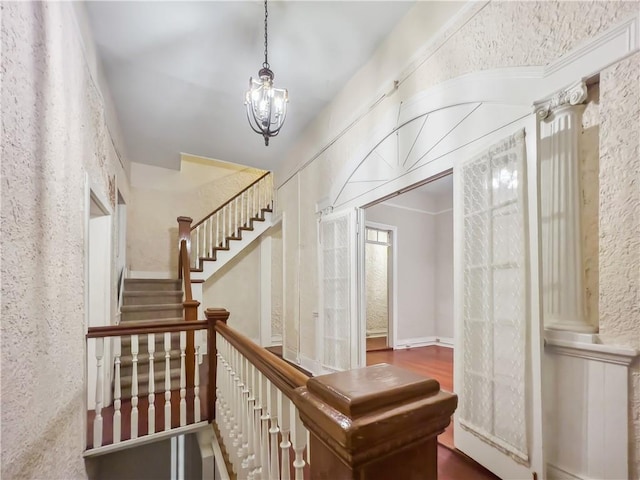 stairway with an inviting chandelier and hardwood / wood-style floors