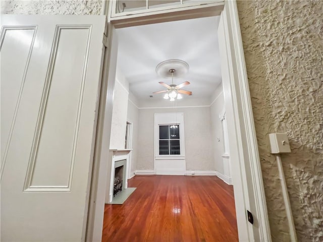 unfurnished living room with ornamental molding, dark hardwood / wood-style floors, and ceiling fan