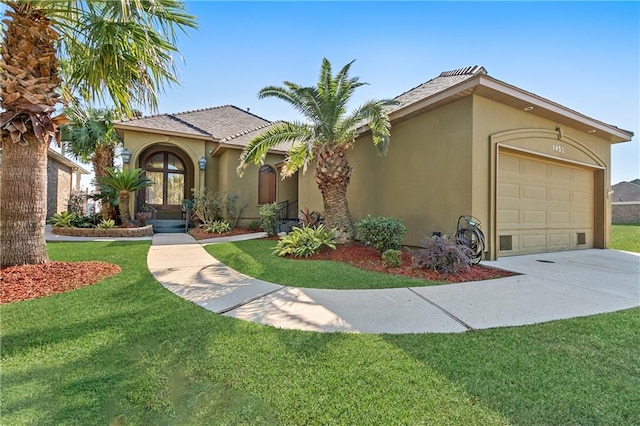 mediterranean / spanish house with a garage and a front lawn