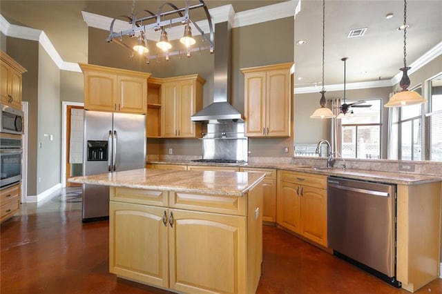 kitchen featuring light brown cabinets, wall chimney range hood, a kitchen island, pendant lighting, and appliances with stainless steel finishes