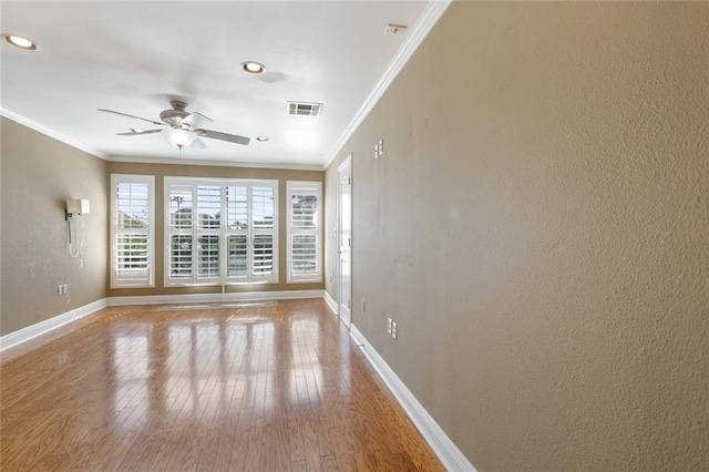 spare room featuring light hardwood / wood-style floors, ceiling fan, and ornamental molding