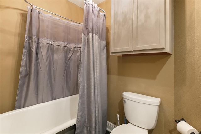 bathroom featuring toilet and shower / bathtub combination with curtain