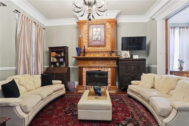 living room with crown molding, a notable chandelier, a fireplace, and a wealth of natural light