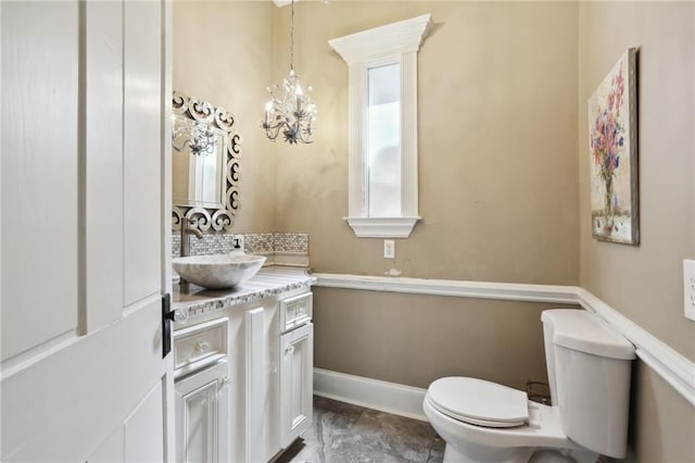 bathroom featuring an inviting chandelier, vanity, and toilet