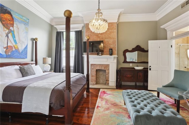 bedroom featuring dark wood-type flooring, a brick fireplace, crown molding, and an inviting chandelier