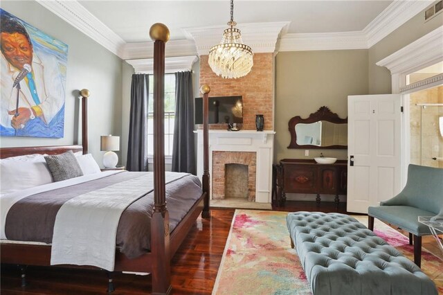 1214 Felicity St, New Orleans, LA 70130 - bedroom featuring a chandelier, crown molding, wood finished floors, and a brick fireplace