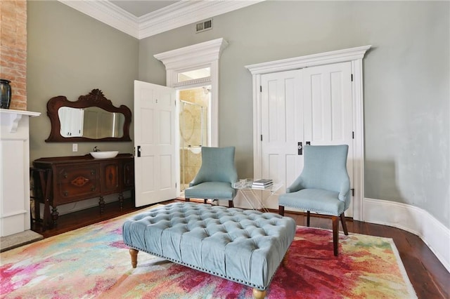 sitting room with ornamental molding, a fireplace, and dark hardwood / wood-style floors