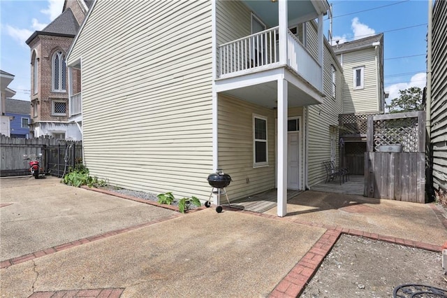 view of side of property with a balcony and a patio