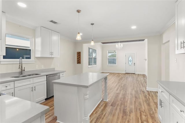 kitchen with white cabinetry, stainless steel dishwasher, sink, and a kitchen island