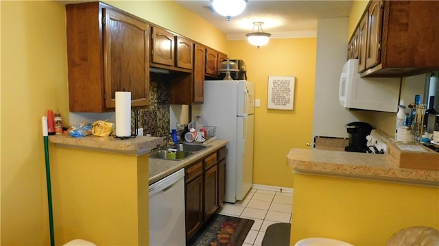 kitchen featuring kitchen peninsula, sink, crown molding, light tile patterned floors, and white appliances