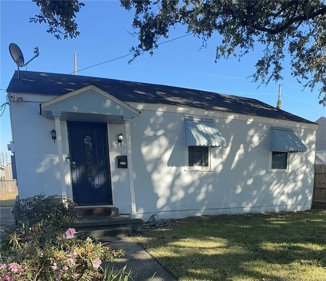 bungalow with fence and a front lawn