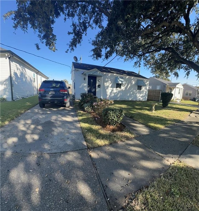 view of front facade featuring driveway and a front yard