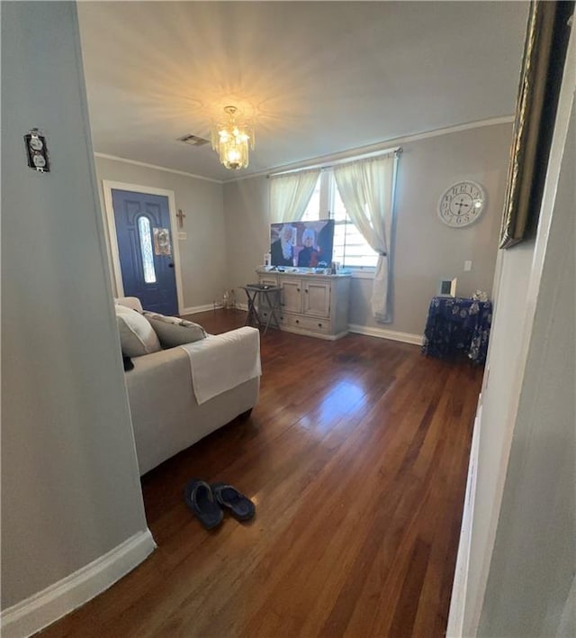 living room with ornamental molding, hardwood / wood-style flooring, and an inviting chandelier