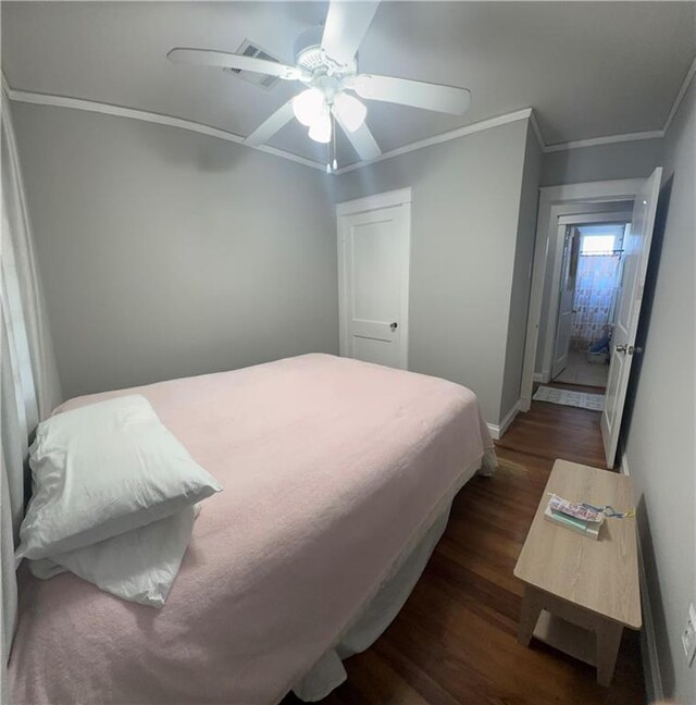 bedroom with crown molding, dark wood-type flooring, and ceiling fan