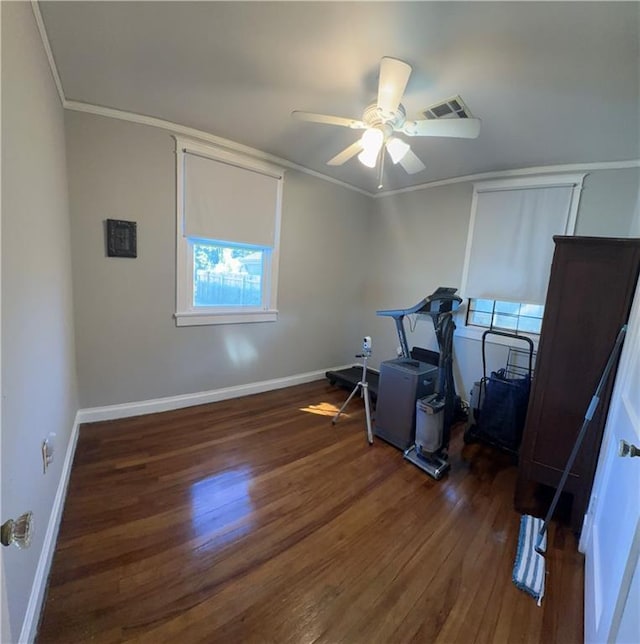 interior space featuring visible vents, ornamental molding, baseboards, and wood finished floors