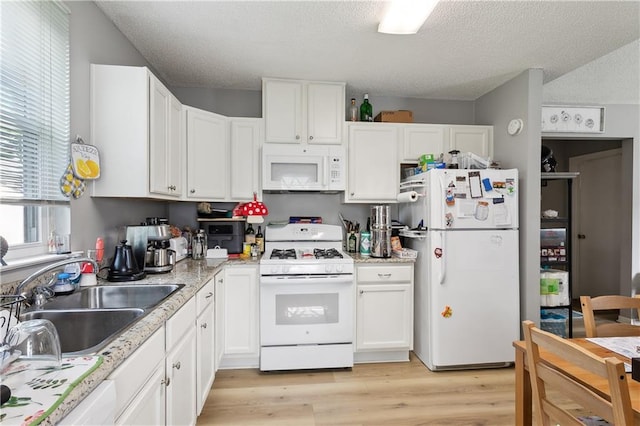 kitchen featuring light wood-type flooring, white appliances, a textured ceiling, sink, and white cabinets