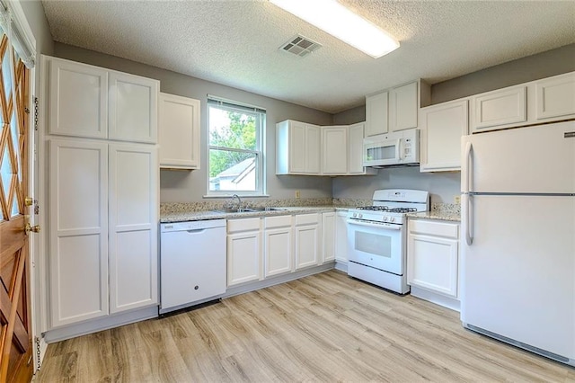 kitchen with white cabinetry, sink, white appliances, and light wood-type flooring