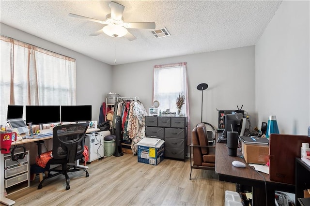 office with a textured ceiling, light wood-type flooring, and ceiling fan