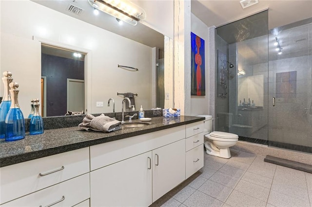 bathroom featuring vanity, tile patterned floors, toilet, and walk in shower