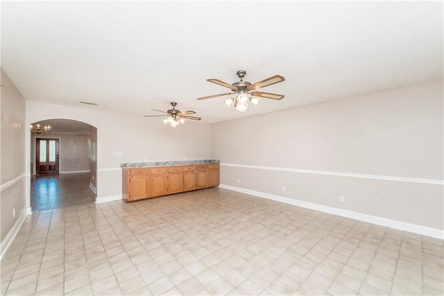 spare room with ceiling fan with notable chandelier