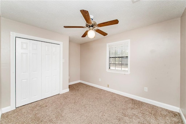 unfurnished bedroom with ceiling fan, carpet flooring, and a textured ceiling