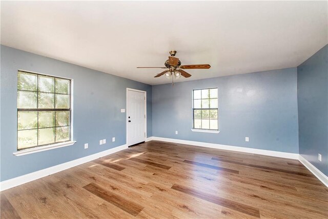 empty room with hardwood / wood-style flooring and ceiling fan