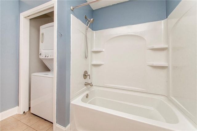 bathroom with tile patterned flooring, bathing tub / shower combination, and stacked washing maching and dryer